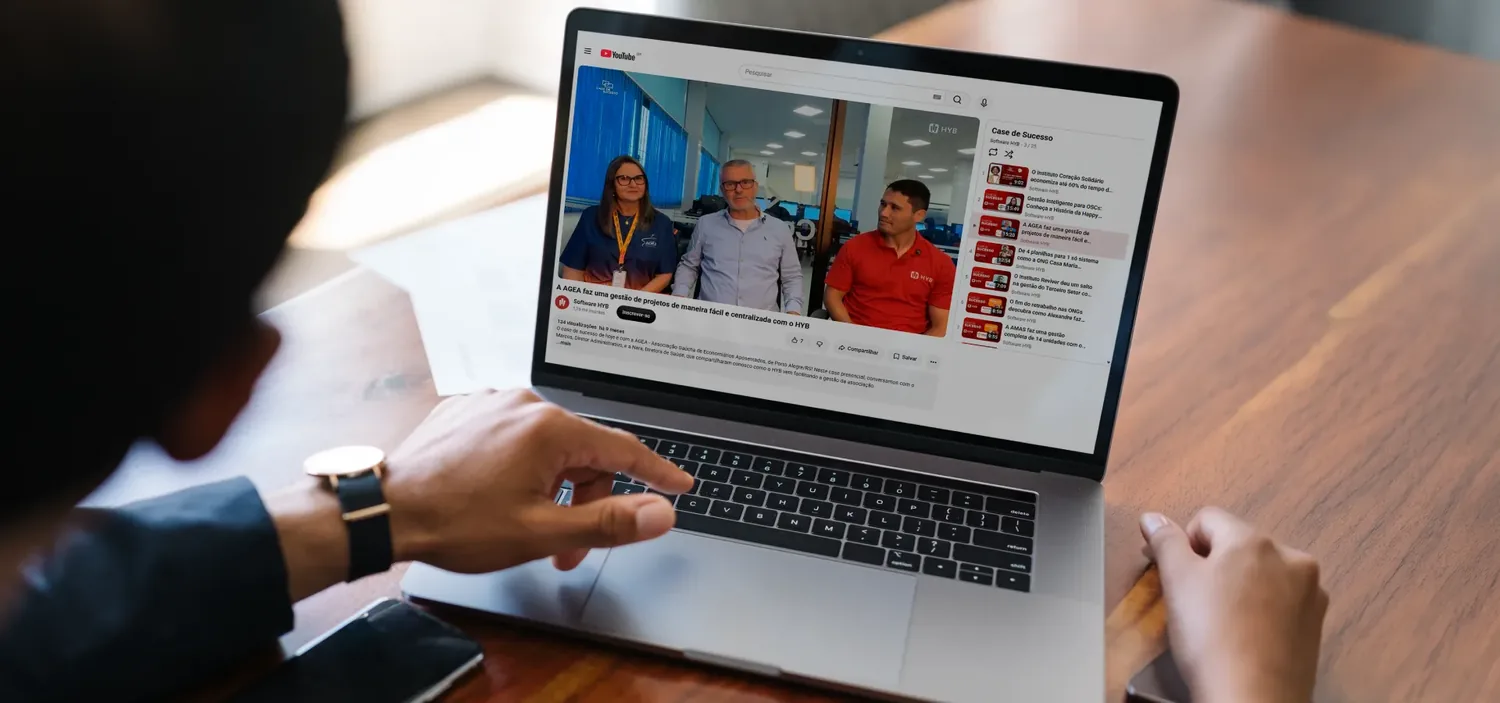Pessoa apontando para a tela de um notebook que exibe a p�gina de cases do HYB