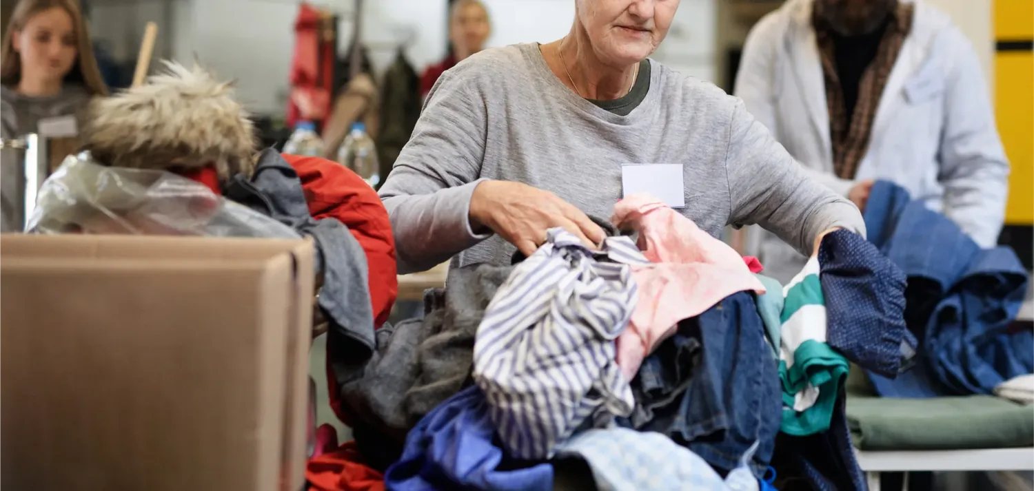 Volunt�rias separando roupas doadas sobre uma mesa