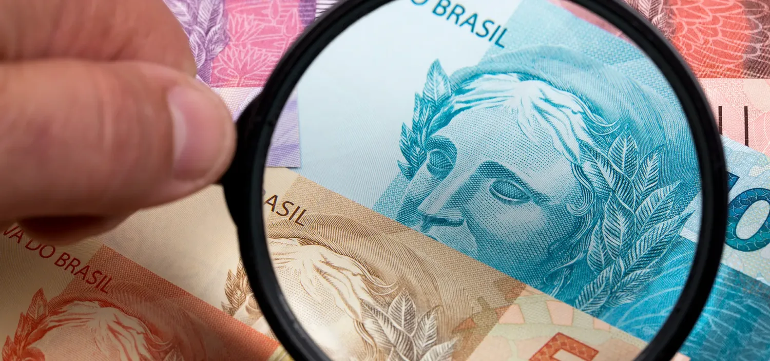 Lupa ampliando os detalhes de uma c�dula de dinheiro sobre outras notas