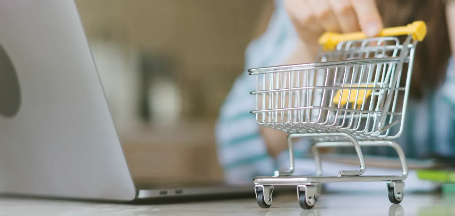 Carrinho de compras em miniatura � frente de um computador