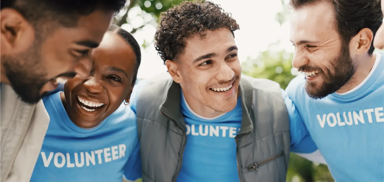 Grupo de volunt�rios com camiseta azul, sorrindo durante uma a��o